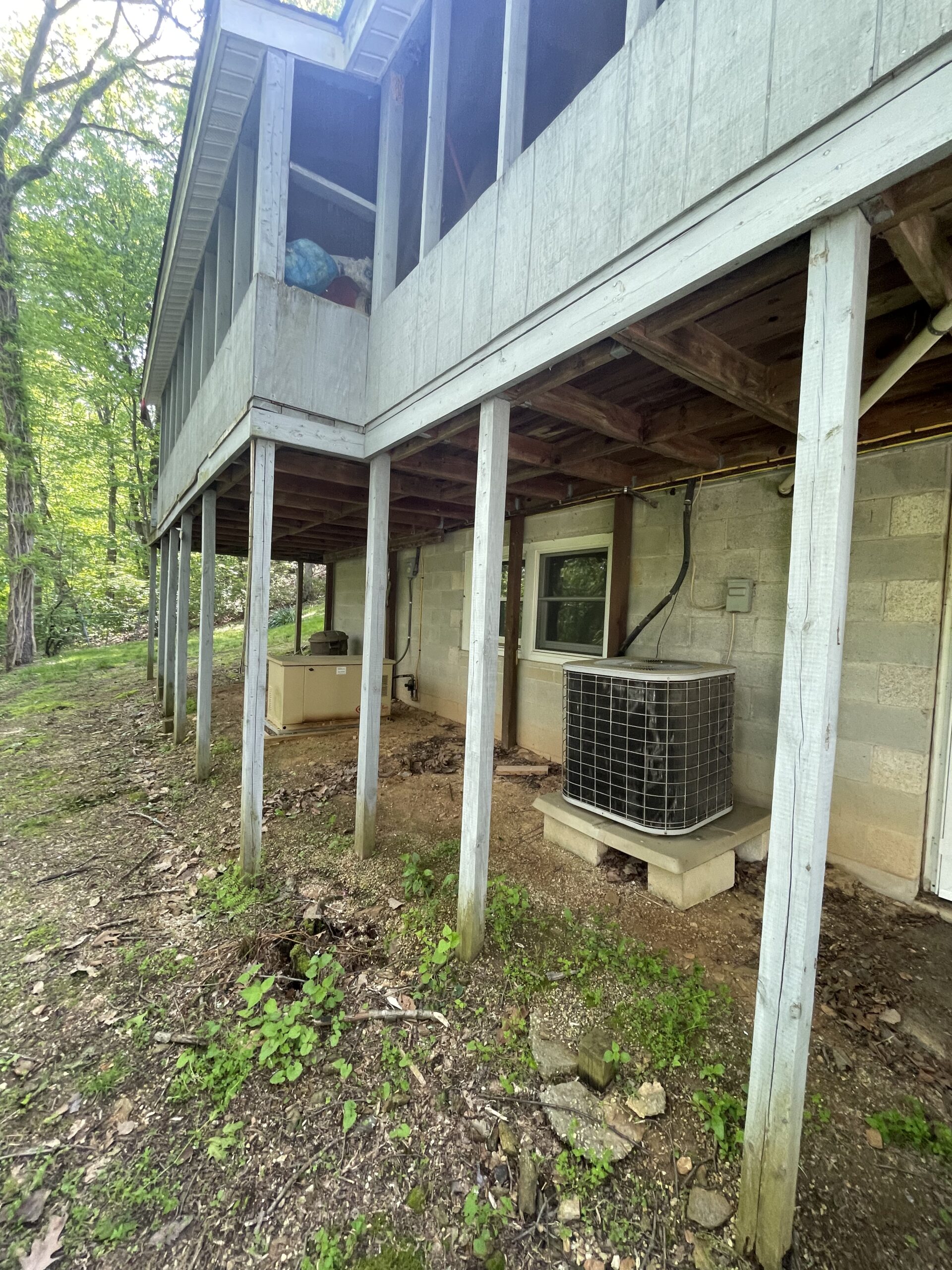Elevated screened porch above a block foundation and air conditioning unit in St. Johns