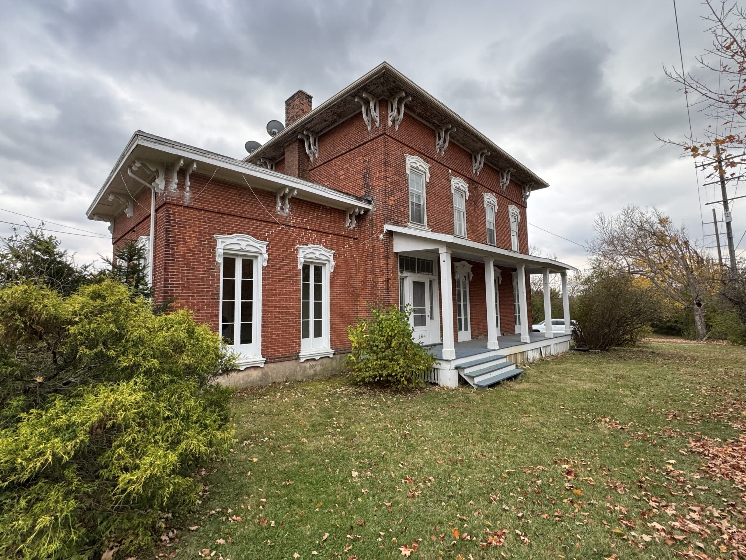 Two story red brick house with a front porch in Eaton Rapids