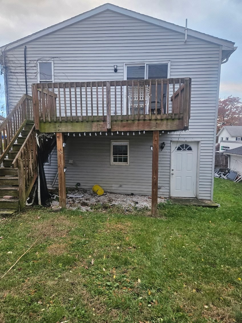 Back of a gray two story house with a raised wooden deck in Perry